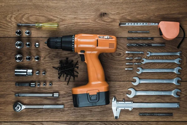 Destornillador inalámbrico y kit de herramientas en una vieja mesa de madera — Foto de Stock