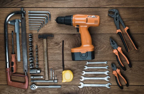 Destornillador inalámbrico y kit de herramientas en una vieja mesa de madera — Foto de Stock