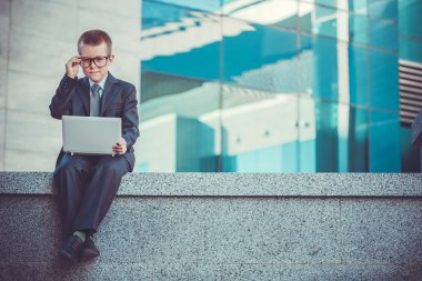 modern arka plan mavi laptop ile çocuk işadamı