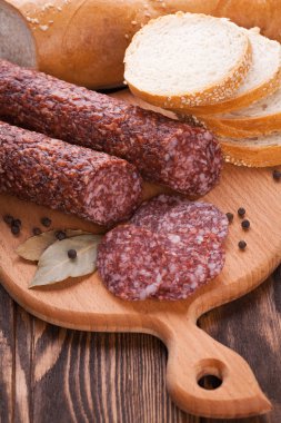 İtalyan salamı ahşap masanın üzerine dilimlenmiş