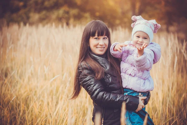 Matka a její dítě bavit v podzimním parku — Stock fotografie