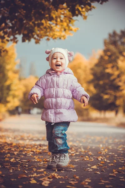 Happy playful baby is running in the autumn park — Stock Photo, Image