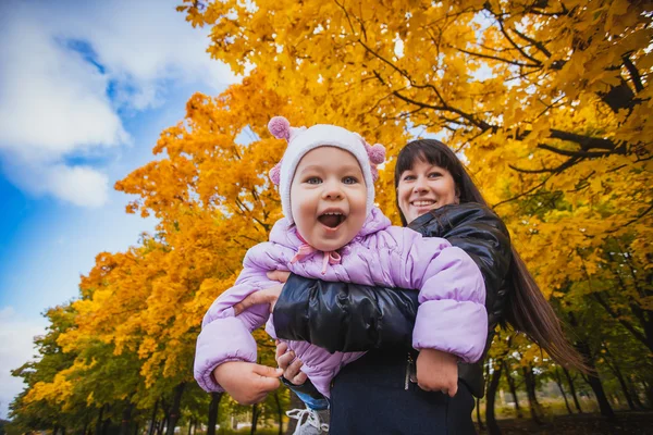 Matka a její dítě bavit v podzimním parku — Stock fotografie