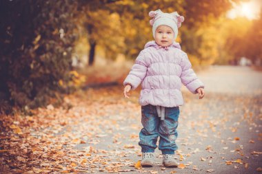 mutlu oynak bebek sonbahar parkta çalışıyor