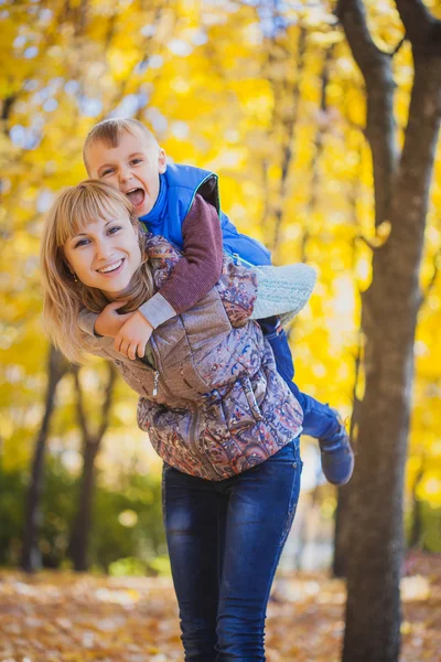 Mother and her kid have fun in the autumn park — Stock Photo, Image