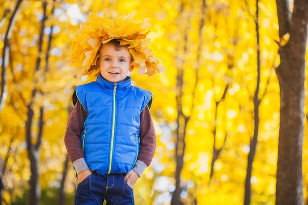 Felice ragazzo giocoso nel parco autunnale — Foto Stock