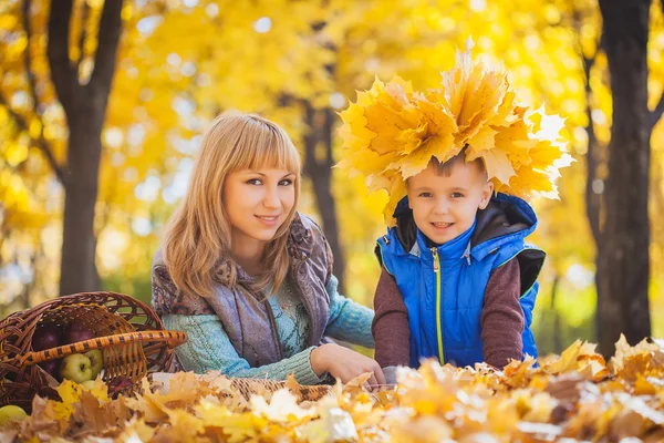 Mutter und ihr Kind haben Spaß in den gelben Blättern — Stockfoto