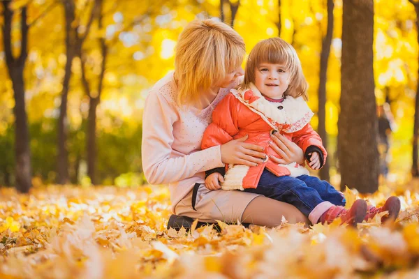 Mutter und ihr Baby im Herbstpark — Stockfoto