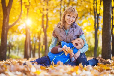 Anne ve oğlu eğlenceli sonbahar parkta var