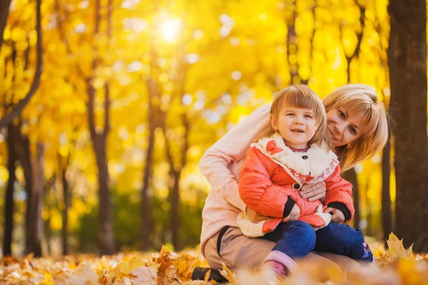 Мама и ее ребенок весело провести время в осеннем парке — стоковое фото