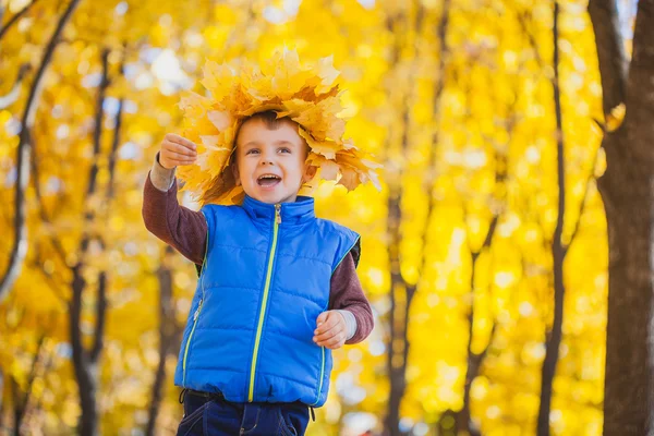 Felice ragazzo giocoso divertirsi nelle foglie gialle — Foto Stock