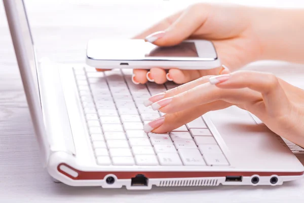Hands with smart phone and computer keyboard — Stock Photo, Image