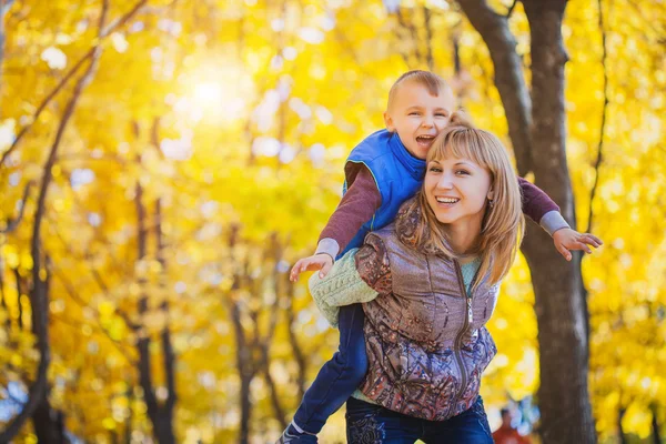 Mère et son enfant s'amusent dans le parc d'automne — Photo