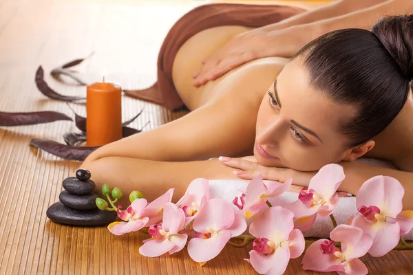 Masajista haciendo masaje en el cuerpo de la mujer en el salón de spa —  Fotos de Stock