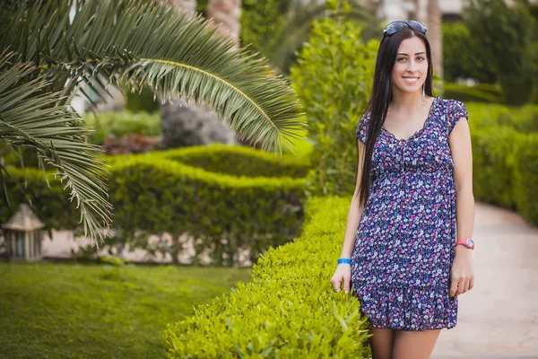 Vrouw is wandelen in de tuin met palmbomen — Stockfoto