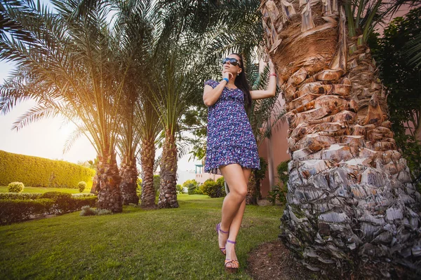 Mulher está andando no jardim com palmeiras — Fotografia de Stock