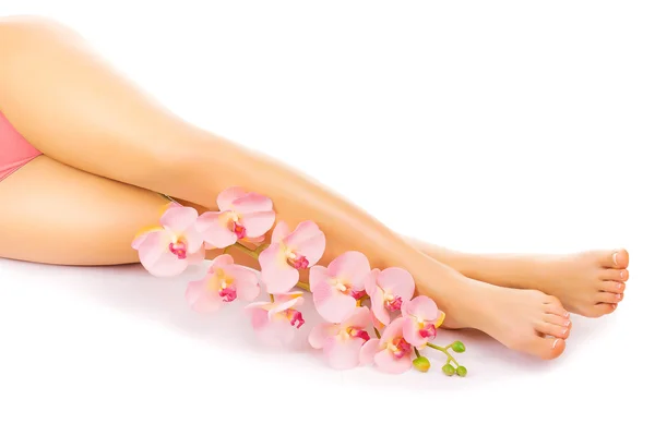 Pedicure met een roze orchideebloem ontspannen — Stockfoto