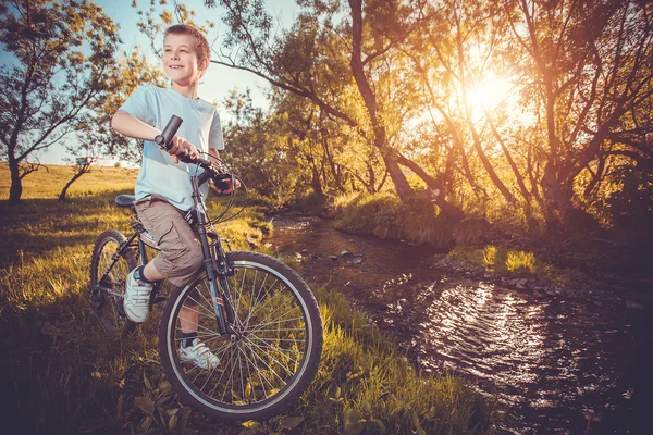 Garoto engraçado feliz na bicicleta. Lazer ativo — Fotografia de Stock