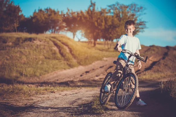 Gelukkig grappige jongen op een fiets. actieve ontspanning — Stockfoto