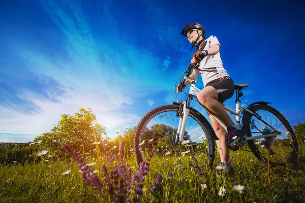 Woman is riding bicycle outside — Stock Photo, Image