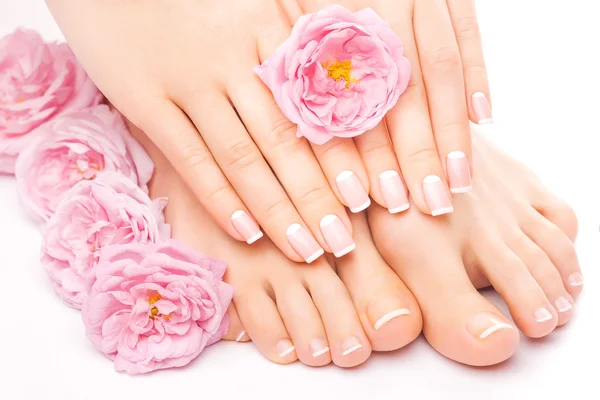 Pedicure e manicure con un fiore rosa rosa — Foto Stock