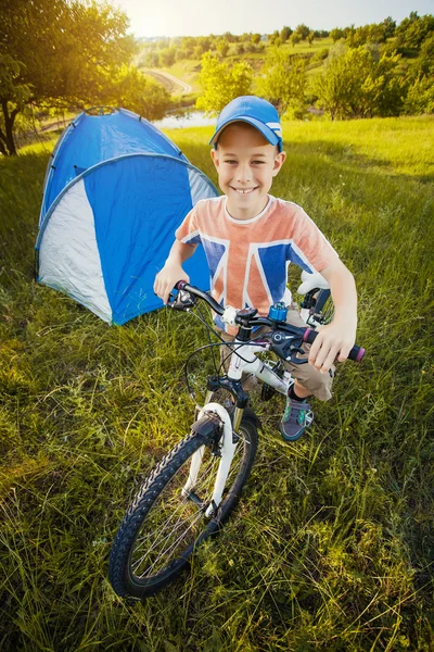 Kid with a tent on a camomile meadow — Stock Photo, Image