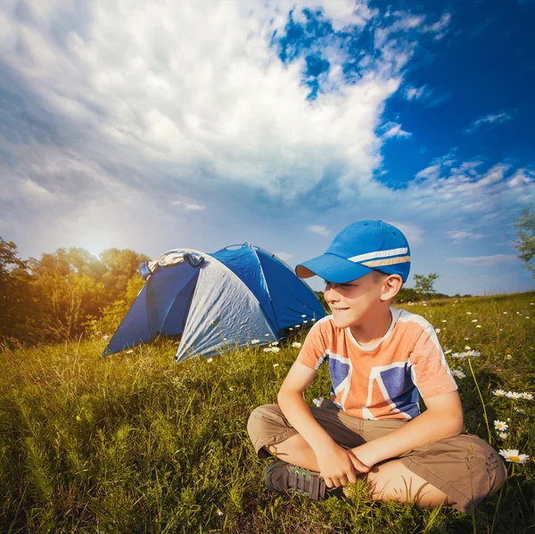 Kid met een tent op een weide kamille — Stockfoto