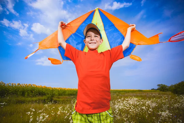 Мальчик запускает воздушного змея в голубое небо — стоковое фото