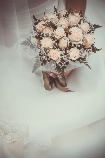 Bouquet de mariée dans les mains des mariées — Photo