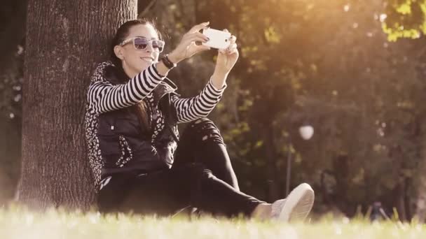 Femme dans un parc prenant une photo sur téléphone portable — Video