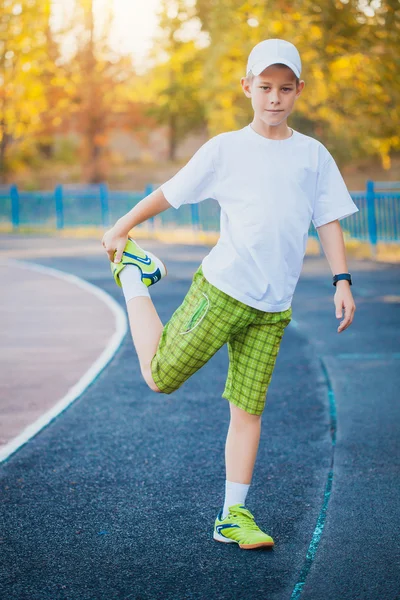 Boy Teen doing sports exercises on a stadium — Stock Photo, Image