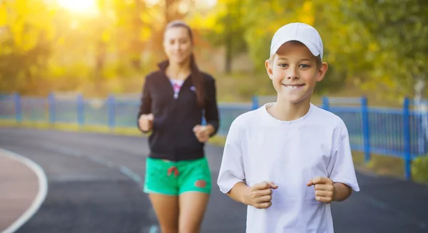 mother and son are running or jogging for sport outdoors