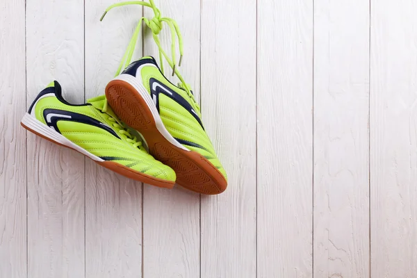 Par de sapatos esportivos em uma parede de madeira branca — Fotografia de Stock