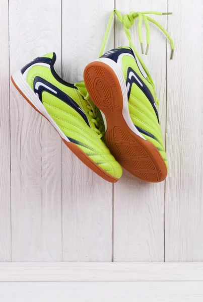 Pair of sport shoes on a white wooden wall — Stock Photo, Image