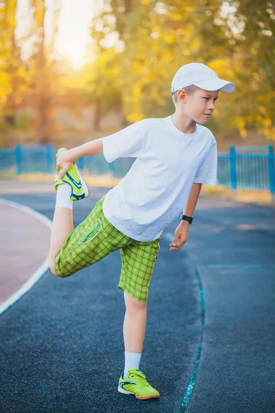 Boy Teen doing sports exercises on a stadium — Stock Photo, Image