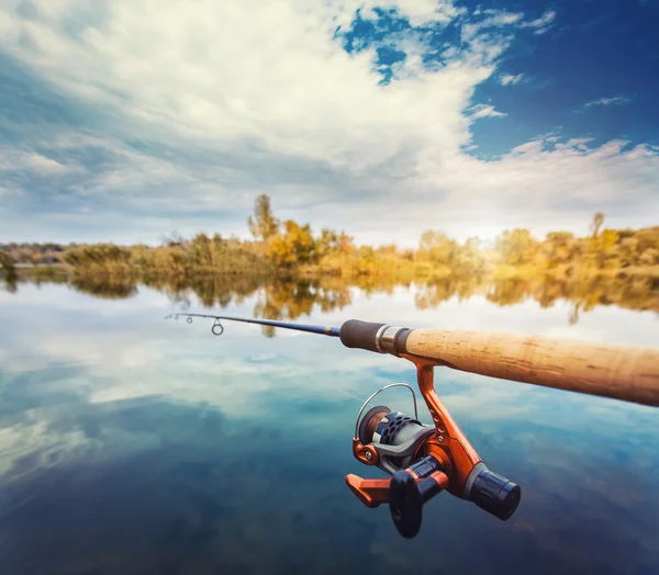 Canna da pesca vicino a bellissimo stagno con cielo nuvoloso — Foto Stock