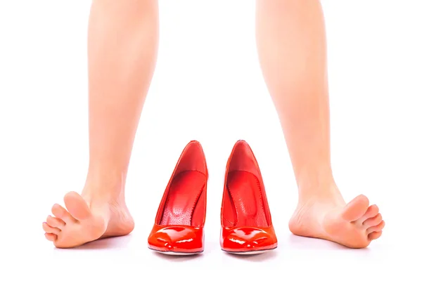 Femmes jambes nues et chaussures rouges sur un fond blanc — Photo