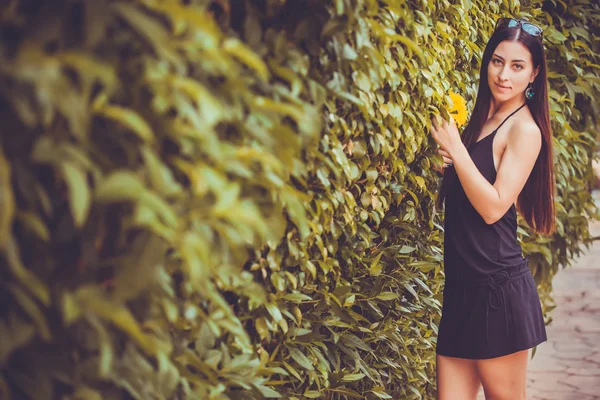 Ung söt kvinna poserar i en grön park — Stockfoto