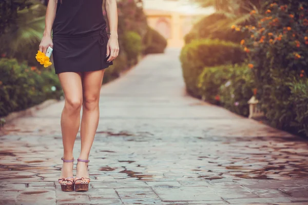 Kvinnliga ben i lila skor promenader i parken — Stockfoto