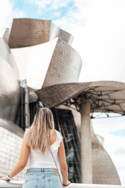 İspanya 'nın Bilbao kentindeki Guggenheim Müzesi' nin dışını ziyaret eden bir kadın.