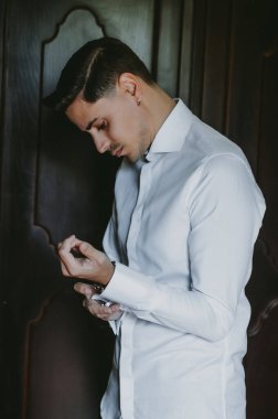 Damat düğünden önce kol düğmelerini takıyor.