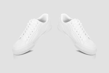 Açık gri bir arkaplan karşısında temel beyaz spor ayakkabıları modeli