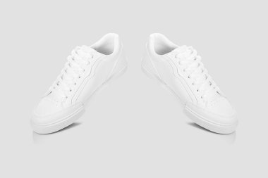 Açık gri bir arkaplan karşısında temel beyaz spor ayakkabıları modeli