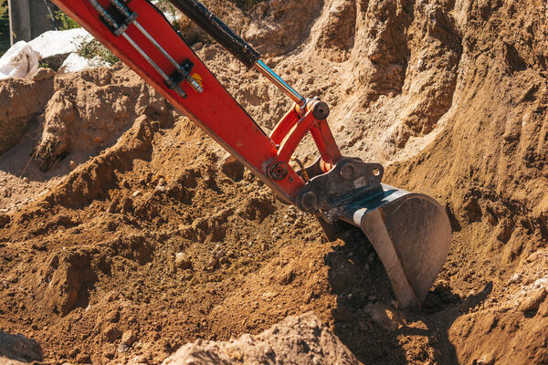 Excavator shovel digging on dirt on a construction site