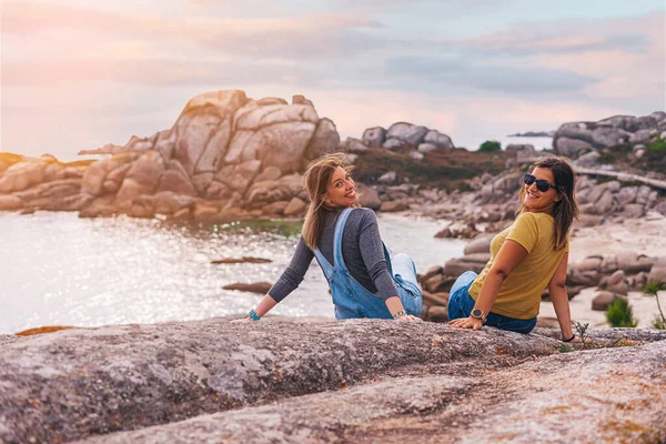 Dos Amigas Sentadas Una Roca Atardecer —  Fotos de Stock