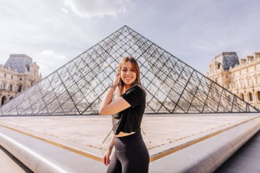 Paris, Fransa 'da Louvre Müzesi önünde poz veren bir turist
