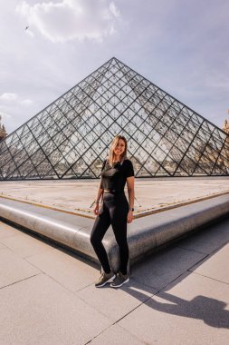 Paris, Fransa 'da Louvre Müzesi önünde poz veren bir turist