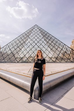 Paris, Fransa 'da Louvre Müzesi önünde poz veren bir turist