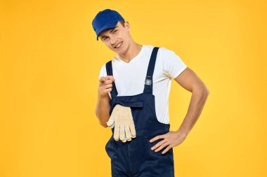 Çalışan üniformalı adam duygularını servis hizmeti sarı arka planda sunuyor