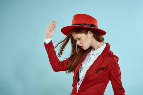 Vacker kvinna i röd hatt jacka röda läppar långt hår charm blå bakgrund — Stockfoto